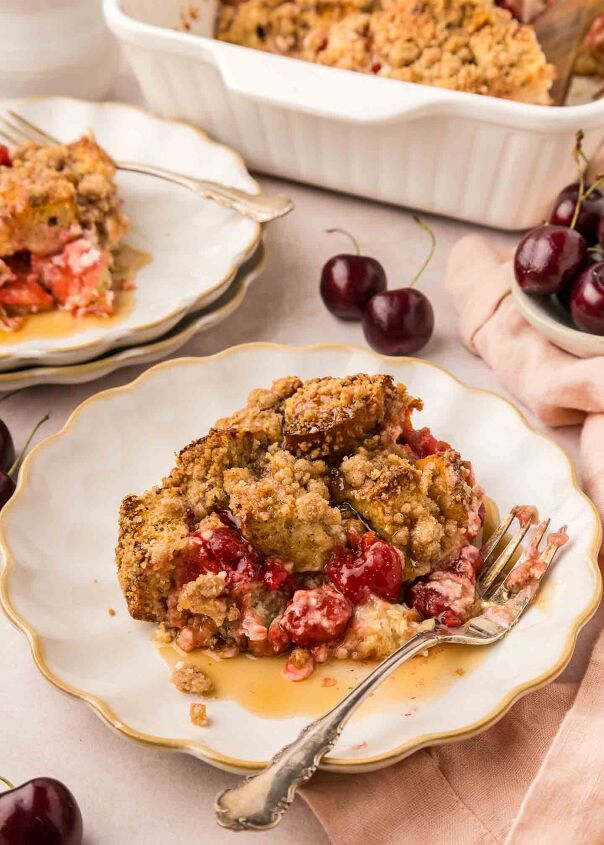 cherry cheesecake french toast casserole, french toast casserole on a white plate with syrup and a fork