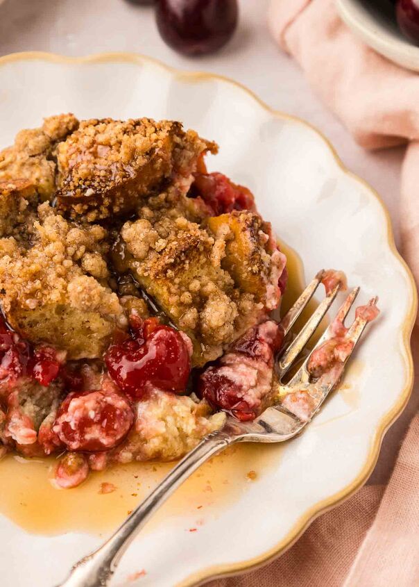 cherry cheesecake french toast casserole, close up of french toast casserole on a white plate with syrup and a fork
