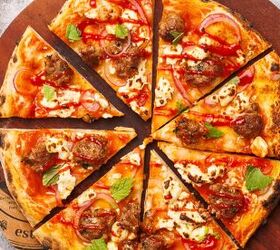 lamb sausage pizza with merguez, Cut lamb sausage pizza on a round wooden board