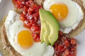 Lightly fried corn tortillas topped with creamy beans, salsa, and a runny egg for an easy yet filling breakfast