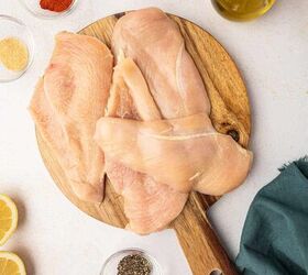 crispy chicken caesar salad, The Chicken breasts are sliced horizontally and placed in a wooden cutting board surrounded by the seasonings
