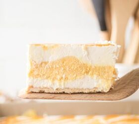 caramel cheesecake bars, A slice of caramel cheesecake bars on a wooden spatula to show the layers