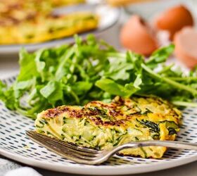 spanish zucchini tortilla, Slice of zucchini tortilla on a plate with a green salad on the side