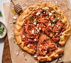spicy carrot feta galette, Overhead shot of spicy carrot and feta galette on a wooden board with one slice coming out on a spatula