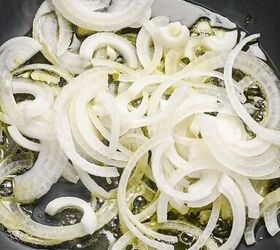 spanish zucchini tortilla, Sliced onions cooking in a skillet with olive oil
