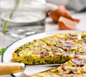 spanish zucchini tortilla, Side view of zucchini tortilla on a plate with a slice missing to see the inside layer