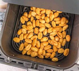 air fryer gnocchi, Seasoned air fryer gnocchi coming out of the air fryer in the basket with a beautiful golden color