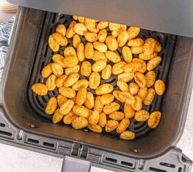 air fryer gnocchi, Seasoned air fried gnocchi coming out of the air fryer in the basket that are beautifully crispy and pillowy