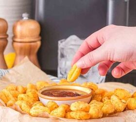 air fryer gnocchi, Dipping a crispy and pillowy piece into marinara sauce in the middle of a serving bowl lined with parchment paper