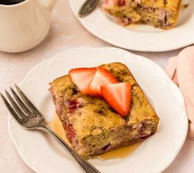 strawberry banana pancake casserole, A slice of strawberry banana pancake casserole is served on a white plate topped with fresh strawberry slices A fork rests beside it In the background theres a cup of black coffee and another plate with a similar slice