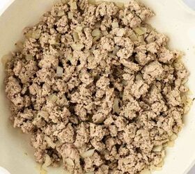 ground turkey with spaghetti, Cooked ground turkey with small pieces of saut ed onion in a white frying pan viewed from above on a light background