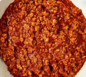 ground turkey with spaghetti, A white skillet filled with cooked ground turkey in a rich red tomato based sauce resembling a homemade meat sauce set against a white background