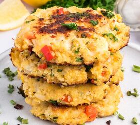 classic crab cake recipe little filler, A stack of four Classic Crab Cakes with visible red peppers and herbs on a white plate garnished with chopped chives