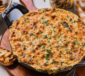 cajun crab spinach artichoke dip, Cajun crab spinach artichoke dip in a cast iron skillet on top of a wooden board