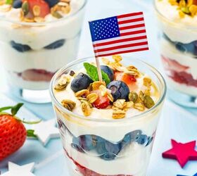 summer berry ricotta parfait easy 4th of july dessert, Side angle shot of summer berries ricotta parfait topped with granola blueberries strawberries and mint leaves with a flag backdrop