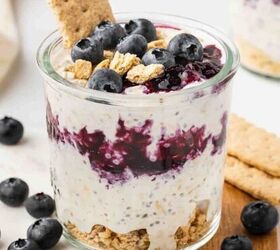 high protein banana split yogurt recipe for breakfast, Blueberry Cheesecake Overnight Oats in a glass cup with blueberries on top