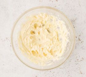 cool whip fruit dip, A glass bowl filled with creamy cool whip powdered sugar vanilla and cream cheese mixed together on a light speckled countertop
