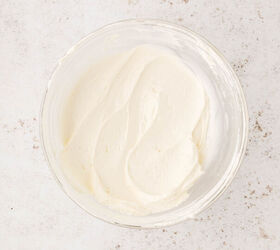 cool whip fruit dip, A glass bowl filled with smooth creamy cool whip dip sits on a lightly speckled off white surface