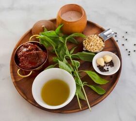 provencal tomatade, Sundried tomatoes fresh basil olive oil pine nuts garlic and salt and pepper on a wooden plate