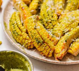 pesto butter corn ribs, Pesto butter corn ribs with parmesan served on a plate with more pesto butter on the side
