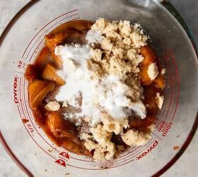 easy peach cobbler pound cake with brown butter glaze, looking down at sliced peaches in a pyrex measuring cup with sugars and spice piled on top of peaches