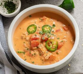 keto taco soup a flavorful and easy low carb meal, A bowl of Keto Taco Soup garnished with sliced green chilies and herbs placed on a gray surface next to a striped cloth and a small bowl of herbs