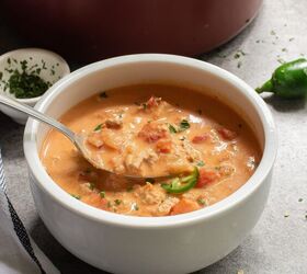 keto taco soup a flavorful and easy low carb meal, A bowl of Keto Taco Soup with chunks of tomatoes and herbs next to a pot A spoon is in the bowl Nearby a jalape o and small dish with herbs A towel is partially visible