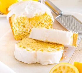 starbucks copycat lemon loaf, A lemon loaf cake with white icing sliced surrounded by fresh lemons and a zester on a marble surface