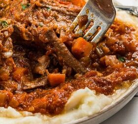 stracotto italian pot roast, A fork lifts braised beef with vegetables and tomato sauce over creamy mashed potatoes