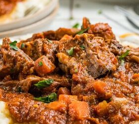 stracotto italian pot roast, A plate of braised beef stew with carrots and tomato sauce served over mashed potatoes