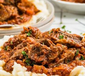 stracotto italian pot roast, Beef stew with tomato sauce served over mashed potatoes on a white plate