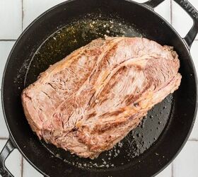 stracotto italian pot roast, A large piece of seared beef in a black cast iron pot on a white tiled surface