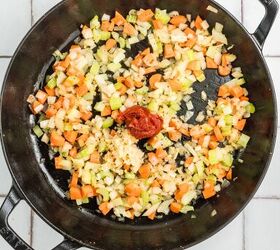 stracotto italian pot roast, Diced carrots celery onion garlic and tomato paste in a black skillet on a tiled surface