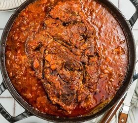 stracotto italian pot roast, Large pot of braised beef in tomato sauce accompanied by mashed potatoes plates and cutlery on the side