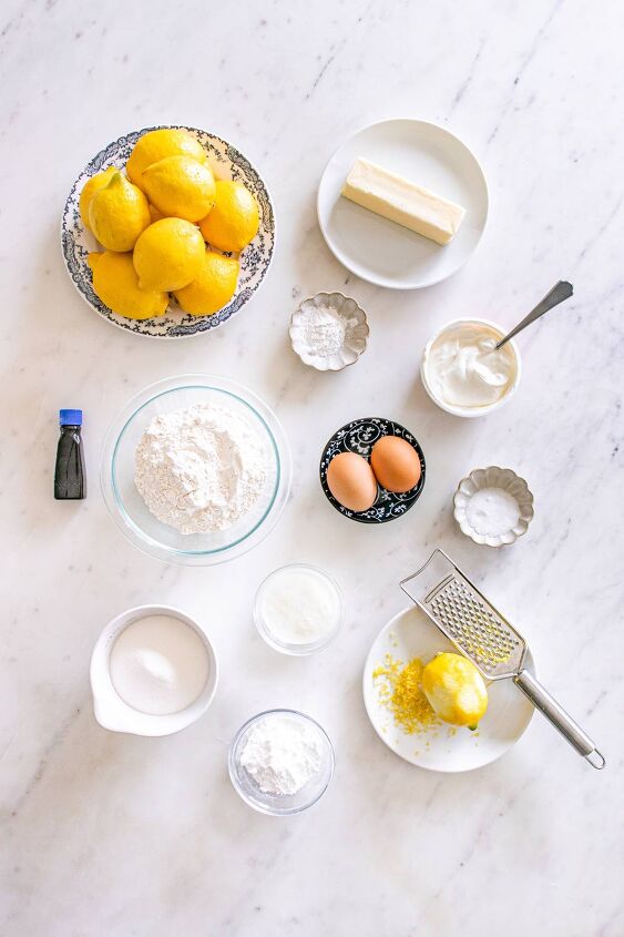 starbucks copycat lemon loaf, Baking ingredients including lemons eggs flour sugar butter and vanilla arranged on a white countertop
