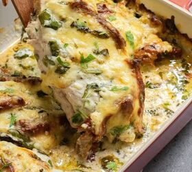 baked tuscan chicken casserole, Baked dish with cheesy herb meal being lifted from a red dish on a gray surface