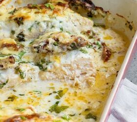 baked tuscan chicken casserole, Baked Tuscan chicken casserole in a red dish topped with melted cheese herbs and a creamy sauce