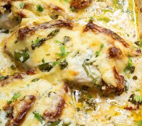 baked tuscan chicken casserole, Baked Tuscan chicken casserole covered in melted cheese and herbs garnished with fresh parsley in a baking dish