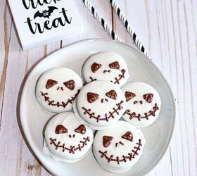 halloween jack skellington cookies with oreos, Plate of Jack Skellington Oreo cookies coated in white chocolate with spooky chocolate faces styled with Trick or Treat decor and Halloween straws