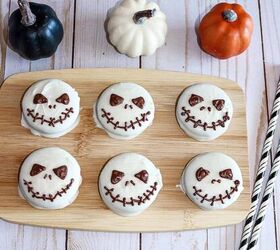 halloween jack skellington cookies with oreos, Halloween Jack Skellington Oreo cookies decorated with white chocolate and dark chocolate faces displayed on a wooden board with mini pumpkins for festive decor