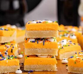 halloween sugar cookie bars, Halloween Sugar Cookie Bars with orange icing stacked on a cutting board