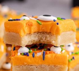 halloween sugar cookie bars, Halloween Sugar Cookie Bars with orange icing sprinkles and eyeballs with a bite taken stacked