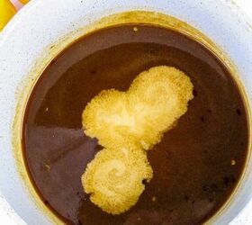 quick and easy teriyaki orange sauce recipe, Cornstarch slurry being poured into dark teriyaki orange sauce in a saucepan with orange slices in the background