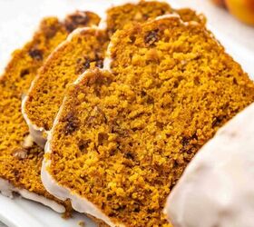 easy pumpkin bread with cake mix moist delicious, Close up of moist pumpkin bread slices stacked on a ceramic platter with a drizzle of vanilla glaze and chopped pecans beside it