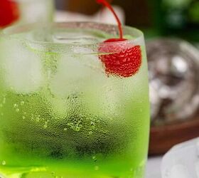 grinch cocktail, Green Grinch Cocktail Over Ice with Maraschino Cherry