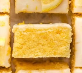 lemon brownies recipe, Close up of lemon brownies topped with white icing and lemon zest with one bar turned sideways to show the moist yellow interior