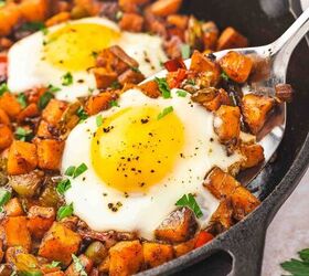 skillet sweet potato breakfast hash easy one pan recipe, Side view of a spatula lifting sweet potato hash and cooked egg from a cast iron skillet
