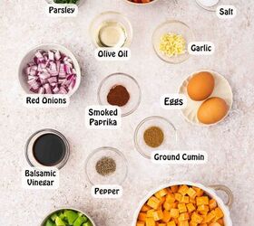 skillet sweet potato breakfast hash easy one pan recipe, Ingredients for sweet potato breakfast hash including diced sweet potatoes chopped bell peppers red onion garlic eggs olive oil and spices on a wooden board