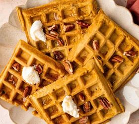 Overhead shot of pumpkin pecan waffles topped with maple syrup and pecans