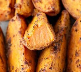 air fryer sweet potato wedges, A close up of roasted sweet potato wedges seasoned with spices showing a crispy exterior and soft orange interior One wedge is cut to reveal its tender inside